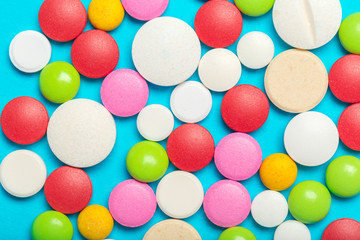 Pills are scattered over a blue background