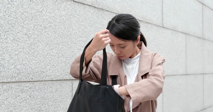 Woman thinking she lost her mobile phone and finding on her bag and jacket pockets