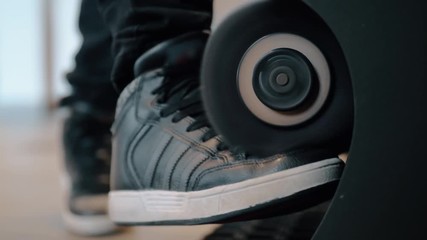 Close-up shot of a boy polishing his black sneakers with automatic electric boot cleaner