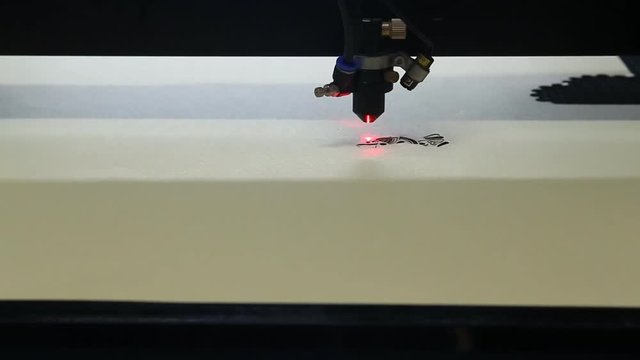 High precision CNC laser at work. Beam of laser cut out tracery from carton board. Modern technologies allow to receive high-precision parts. 