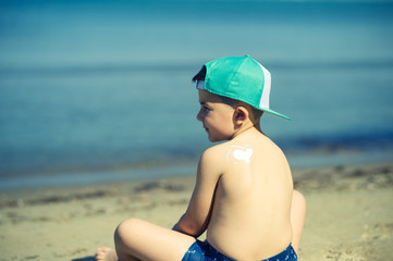 sun protection- little boy with suncream at beach