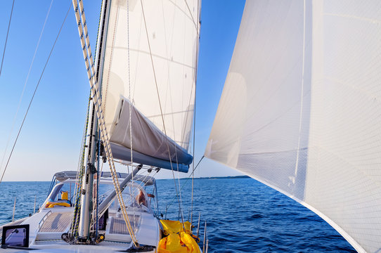 View from a sailboat's bow with mast and full sails