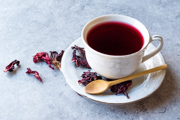 Red Hot Hibiscus Tea in White Cup with Dried Hibiscus Tea Leaves.