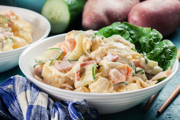 Delicious potato salad with ham, egg and cucumber