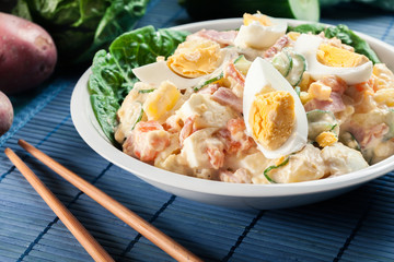Delicious potato salad with ham, egg and cucumber