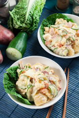 Delicious potato salad with ham, egg and cucumber