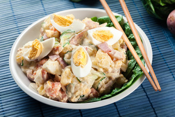 Delicious potato salad with ham, egg and cucumber