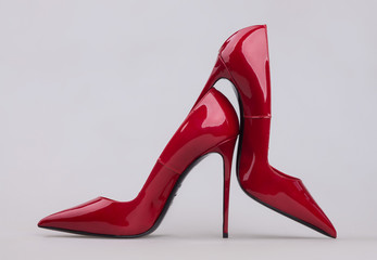 Women's red shoes with a varnish on a gray background