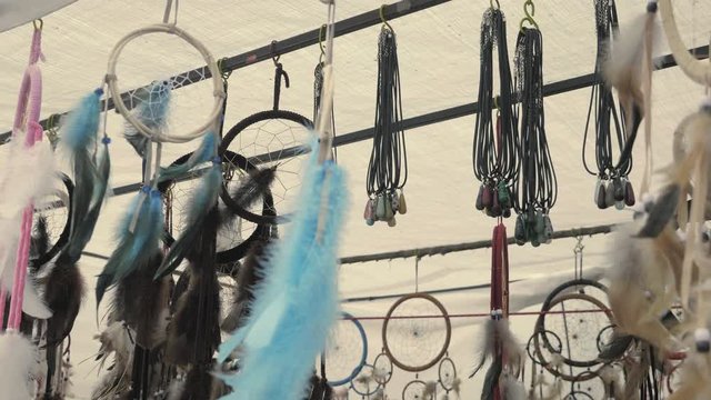 Dream catchers sprinkled swinging in the wind. With feathers and beads. Indian cultural monument, ritual object