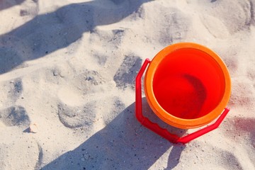empty toy pail on sand with place for text