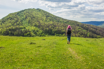 Fototapeta na wymiar soft focus backpack travel girl with pink hair back to camera on beautiful nature forest mountain landscape