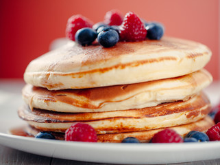 Pancakes with berries and maple syrup.
