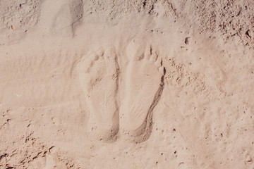 Wave of the sea on the sand beach, summer sand beach background with footprint