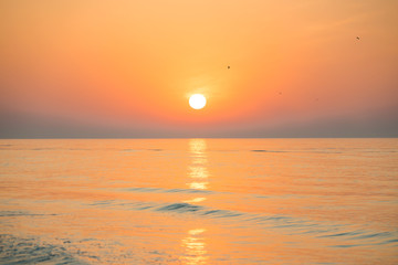 Sunset or sunrise over sea with sun on beautiful dramatic sky