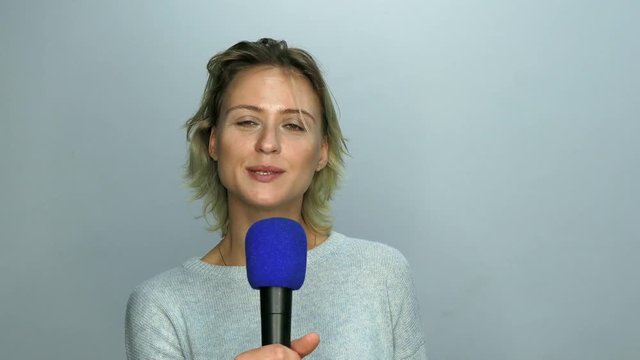 Girl reads text in microphone from mobile phone