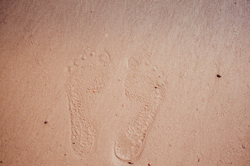 Wave of the sea on the sand beach, summer sand beach background with footprint