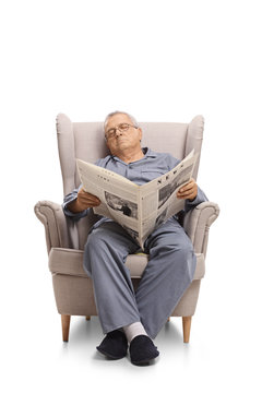 Mature man with a newspaper sleeping in an armchair