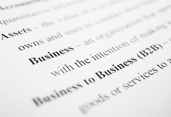 Closeup of popular business-related terms and their respective definitions on the white paper.