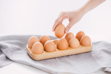 hand picking an egg from egg tray.