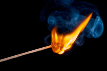 Burning match isolated on black background