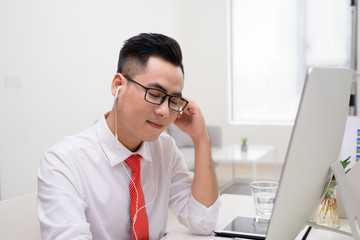 Architect in office talking to client on phone with earphones