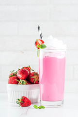 Cold strawberry  milkshake with fresh berries and mint on white marble background copy space