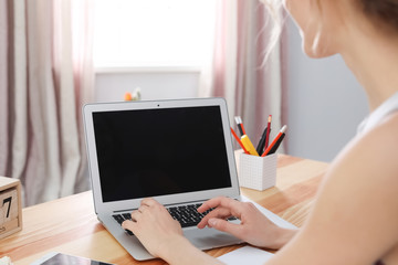 Young woman working with laptop at desk. Home office