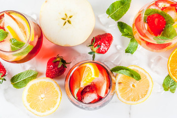 Cold white, pink and red sangria cocktails with fresh fruits, berries and mint. above