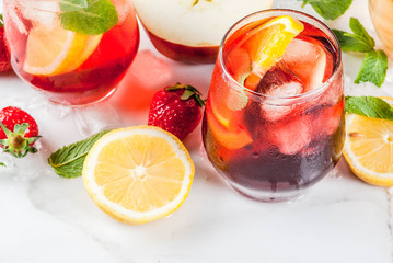 Cold white, pink and red sangria cocktails with fresh fruits, berries and mint.