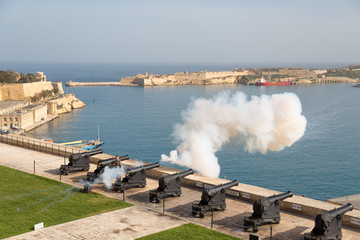 The Saluting Battery, Batterija tas-Salut, an artillery battery, firing ceremonial gun salute signal as seen from the Upper Barrakka Gardens. - 203228964