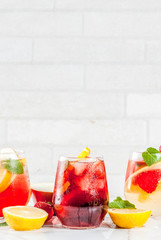Cold white, pink and red sangria cocktails with fresh fruits, berries and mint.