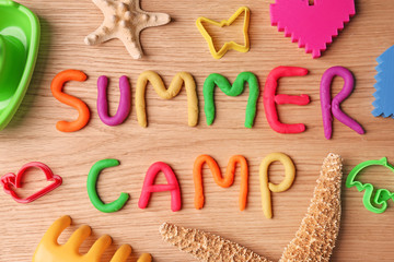 Fototapeta na wymiar Text SUMMER CAMP made with play dough on wooden background, top view