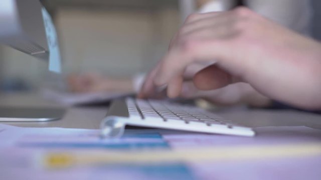 Close uo of male hands which are typing financial report on keyboard in the office. Concepts: business, businesspeople, work, success, technology. 4k,