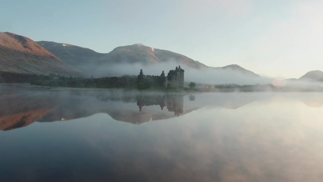 Incredible aerial drone shot of Kilchurn Castle with low mist, Scotland
