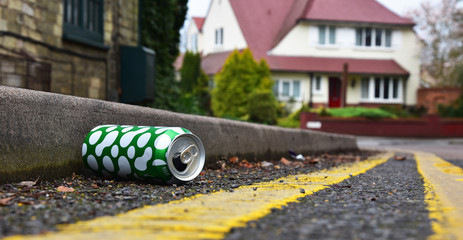 Obraz premium Discarded drinks can lying at the edge of an urban street