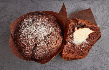 Chocolate muffins filled with cream cheese on a wooden table