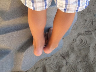 Child climbing a rock wall with bare feet