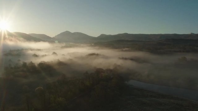 Low hanging mist over tree's near Kilchurn castle, Scotland