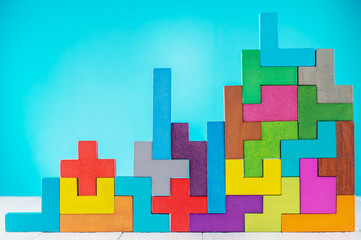 Different colorful shapes wooden blocks on blue background. Geometric shapes in different colors, top view.  Copy space.