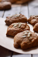 Home made pumpkin scones Cookies decorated with seeds lie on paper for packaging