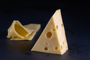 Piece of cheese on on black background