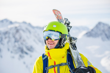 Photo of man wearing helmet wearing glasses with skis