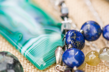 Pendant made of lazurite stone and onyx stone. Gemstone bracelets and necklaces on rustic, natural background. Powerful and healing crystal energy.