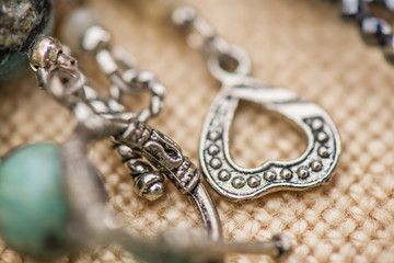 Heart - shaped silver clasp on a gemstone necklace on rustic, natural background.