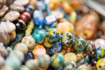 Macro shot of rhodochrosite stone, jasper, glass, hrizokola stones. Gemstone bracelets and necklaces in a row. Healing, powerful energy for crystal therapy treatments and reiki. Esoteric background.