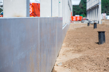 Industrial construction site of new shopping mall in a city. Reinforced concrete piles foundation for the building. Freshly made grouting base pole for block building