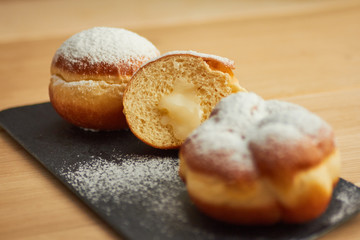 sweet donut sprinkled with powdered sugar on a plate closeup