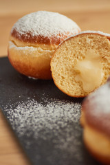 sweet donut sprinkled with powdered sugar on a plate closeup