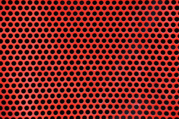 Red metal background with round holes.