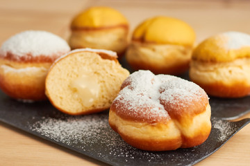 sweet donut sprinkled with powdered sugar on a plate closeup